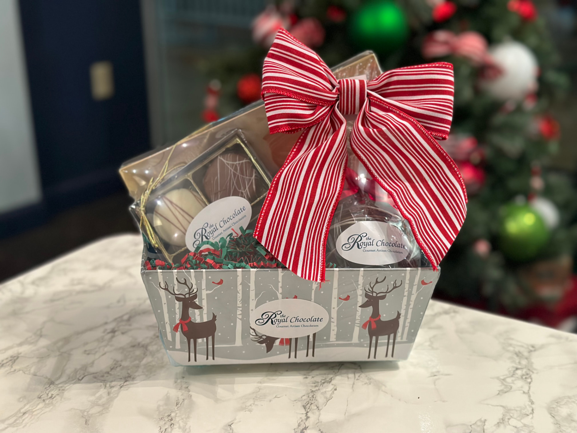 Holiday gift basket with red ribbon and assorted chocolates